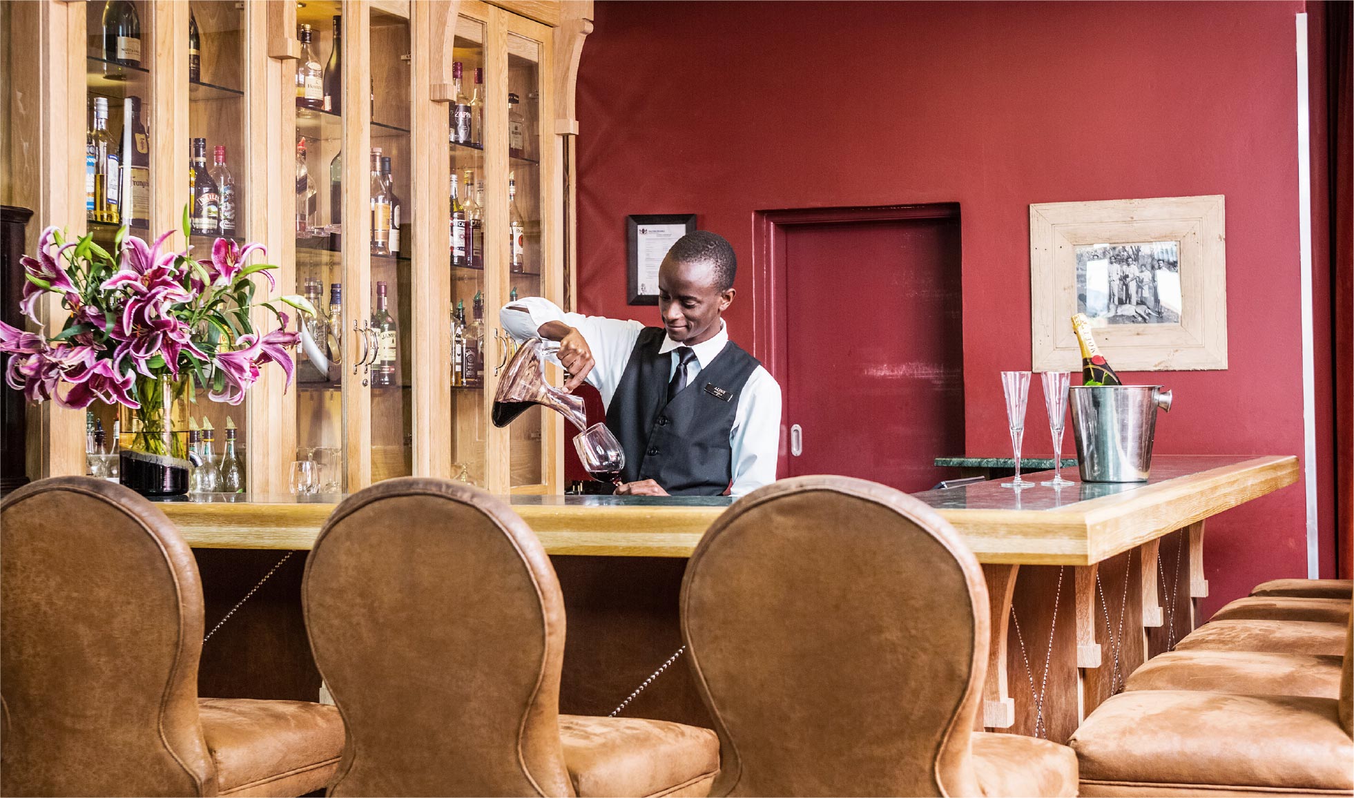 Barman pouring drinks behind bar couter
